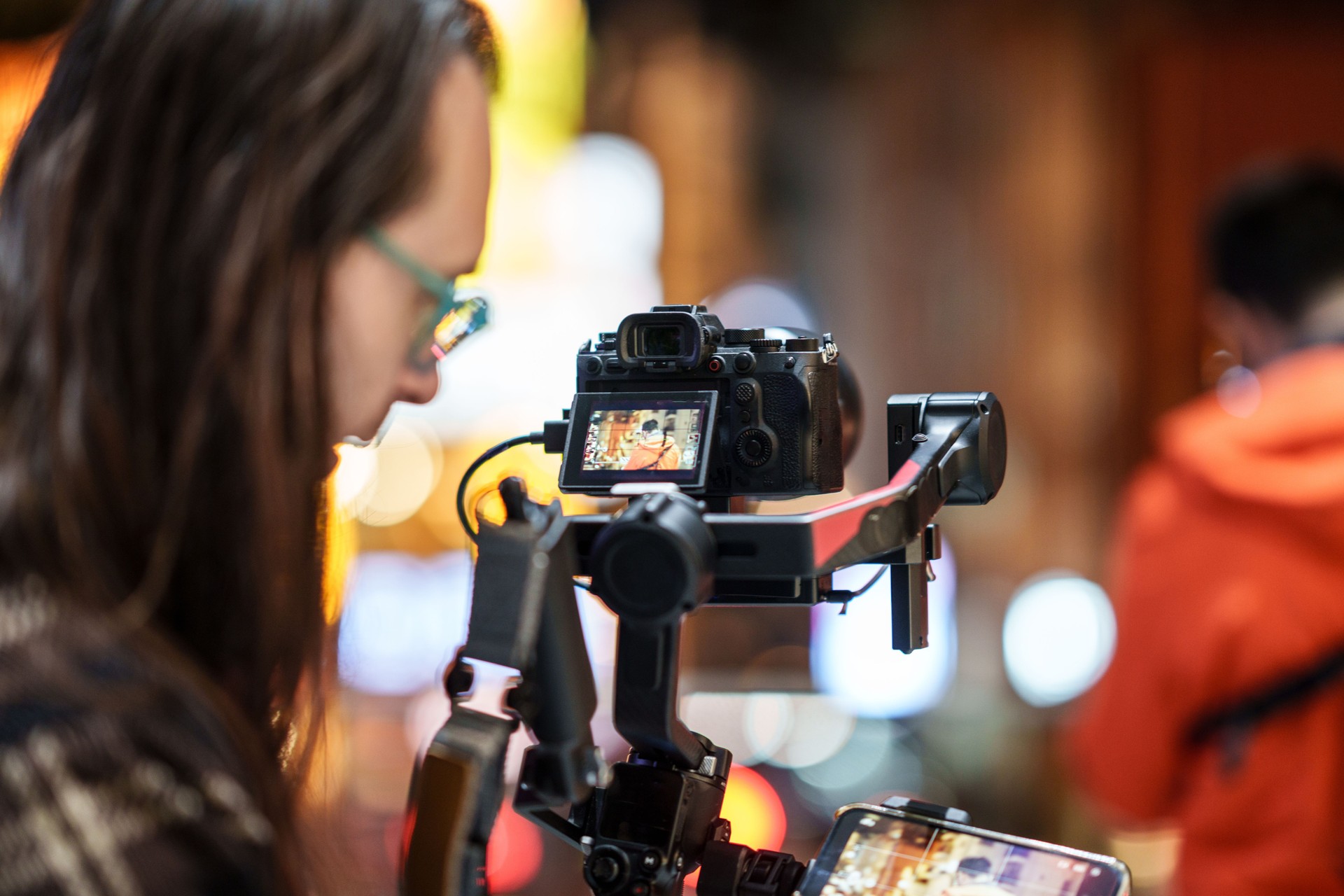 Cameraman filming with camera with gimbal in street.