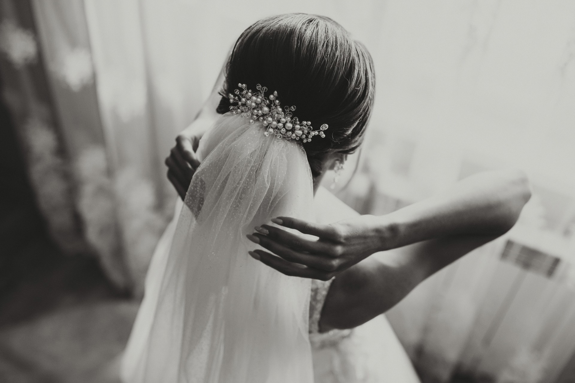classic bridal hairstyle from behind, close-up, veil secured with handmade tiara.